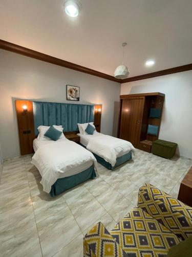 a hotel room with two beds and a couch at أبو بندر للشقق المخدومة in Ar Rass
