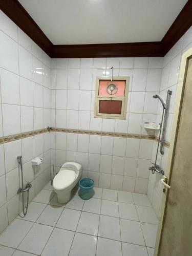 a bathroom with a toilet and a picture on the wall at أبو بندر للشقق المخدومة in Ar Rass