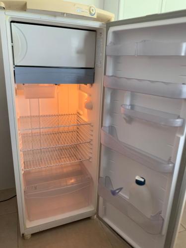 an empty refrigerator with its door open in a kitchen at Mirante do Lago in Capitólio