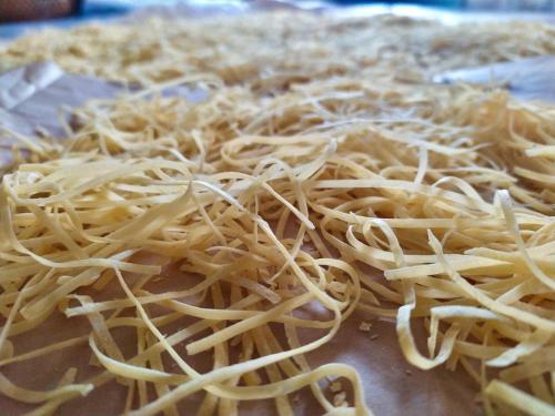 a pile of noodles sitting on top of a pizza at Tourist Farm Strle With Great Local Food in Cerknica