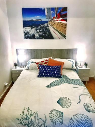 - une chambre avec un grand lit et un couvre-lit sur le thème de l'océan dans l'établissement Appartement ou Studio la mer & la plage à vos pieds CALVI, à Calvi