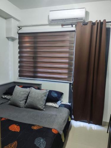 - une chambre avec un lit et une fenêtre avec un store dans l'établissement Unit near mall of asia, à Manille