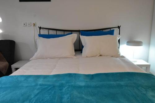 a bed with blue and white sheets and pillows at Sideroporta castle Náfpaktos in Nafpaktos