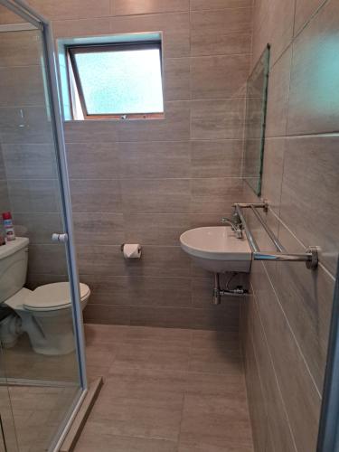 a bathroom with a sink and a toilet at Candleberry Stay in East London