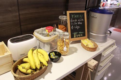 a counter with bananas and other food items on it at Jam Hostel Bangkok in Bangkok