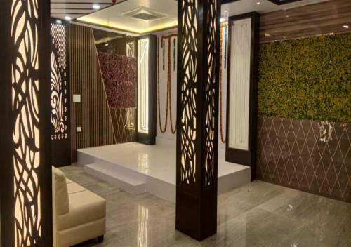 vestíbulo con sofá y pared con plantas en Mayur Palace By WB Inn en Agra