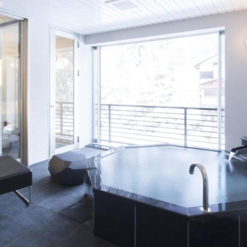 a bathroom with a large tub with a large window at Namari Onsen Kokoro No Toki Jusangatsu in Hanamaki