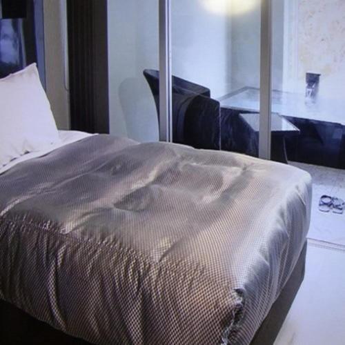 a bed in a room with a table and a mirror at Namari Onsen Kokoro No Toki Jusangatsu in Hanamaki