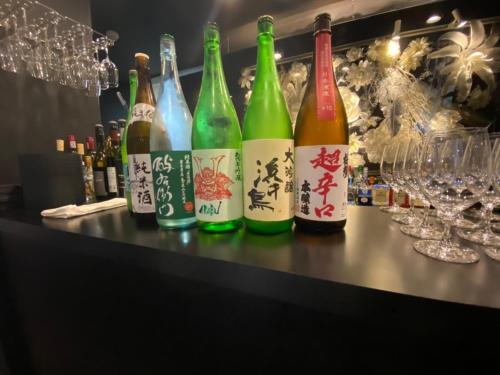 una fila de botellas de vino sentadas en un bar en Namari Onsen Kokoro No Toki Jusangatsu, en Hanamaki