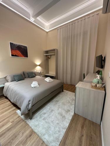 a bedroom with a bed and a television in it at Etna Vibes Home in Catania