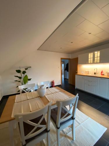 a kitchen and dining room with a wooden table and chairs at Moderne Ferienwohnung Seeblick in Freudenberg