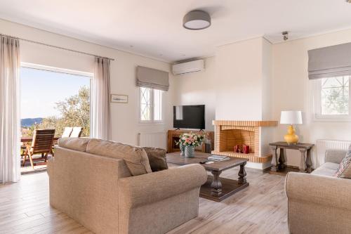 a living room with two couches and a tv at Villa Katrin in Pylos
