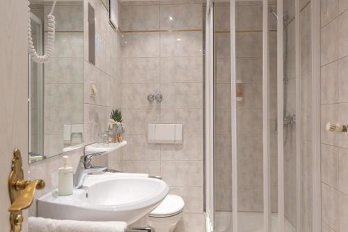 een badkamer met een douche, een wastafel en een toilet bij Hotel Residence in Würzburg