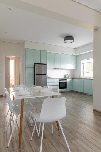 a dining room with a table and white chairs at Villa Katrin in Pylos