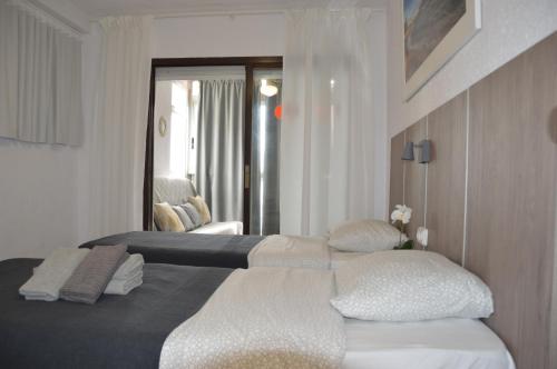 ベニドルムにあるApartamentos Provimaのベッド2台と窓が備わるホテルルームです。