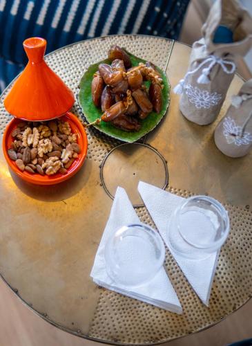 a table with two plates of food and a bowl of nuts at Riad villa saphir & SPA in Marrakech