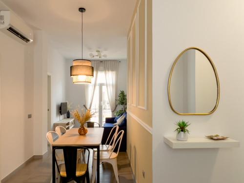 a dining room and living room with a table and a mirror at Maritime Apartamentos Valencia in Valencia