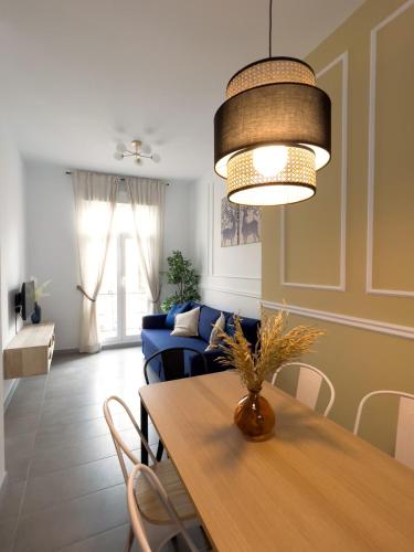 a living room with a table and a blue couch at Maritime Apartamentos Cabañal in Valencia