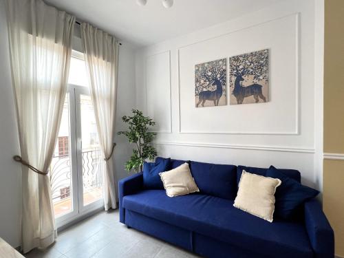 a blue couch in a living room with a window at Maritime Apartamentos Valencia in Valencia