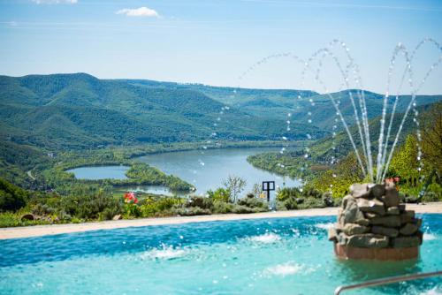 a swimming pool with a view of a lake at Silvanus Hotel in Visegrád