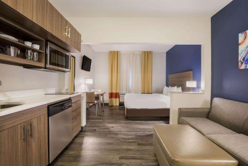 a hotel room with a bed and a kitchen at MainStay Suites Joliet I-55 in Joliet