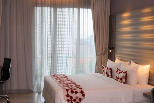1 dormitorio con cama grande y ventana grande en Ramada Suites by Wyndham Kuala Lumpur City Centre, en Kuala Lumpur