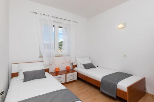 una camera con due letti e una finestra di BENTO apartment - best VIEW on town and sea a Pučišća
