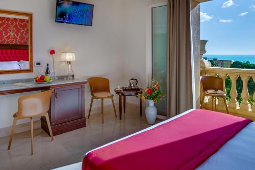 a bedroom with a bed and a table and chairs at La Paloma Blanca Hotel in Sciacca