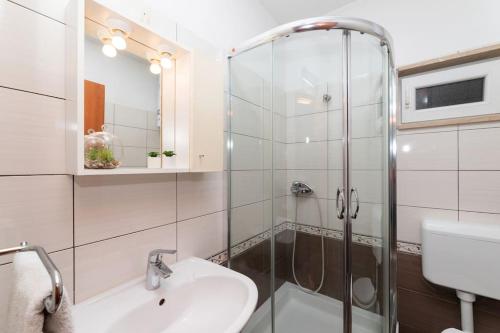 BENTO apartment - best VIEW on town and sea في بوتشيتشا: حمام مع دش زجاجي ومغسلة