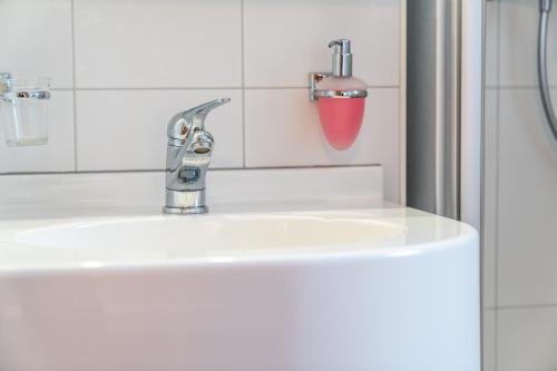 a white bathroom sink with a faucet at Hotel Kristall-Saphir Superior in Saas-Almagell