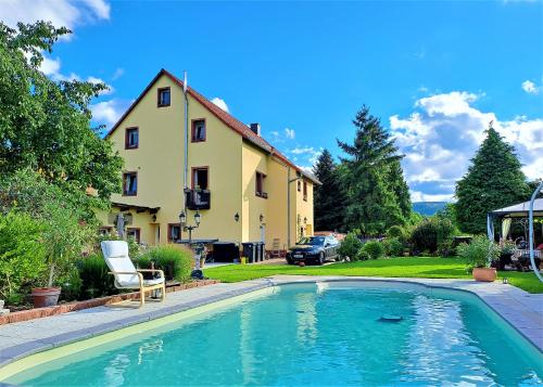 a swimming pool in front of a house at Apartamento Albertina in Kleinheubach