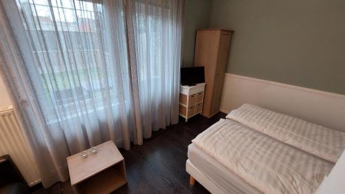 een kleine slaapkamer met een bed en een raam bij Studio Noordstraat 26 in Zoutelande
