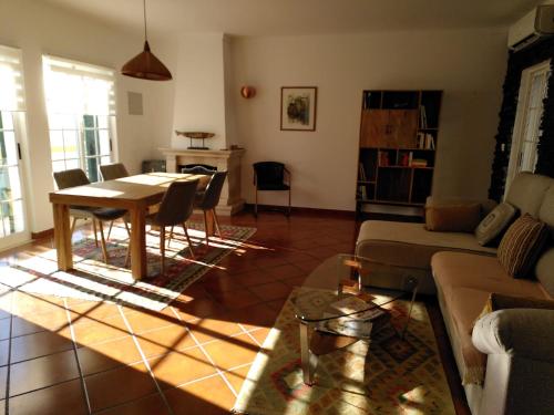 a living room with a table and a couch at BRIGHT AMBIENCE by Stay in Alentejo in Vila Nova de Milfontes