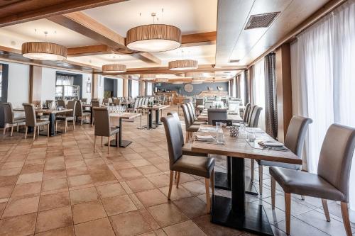a restaurant with tables and chairs in a room at Ravelli Sporting in Mezzana