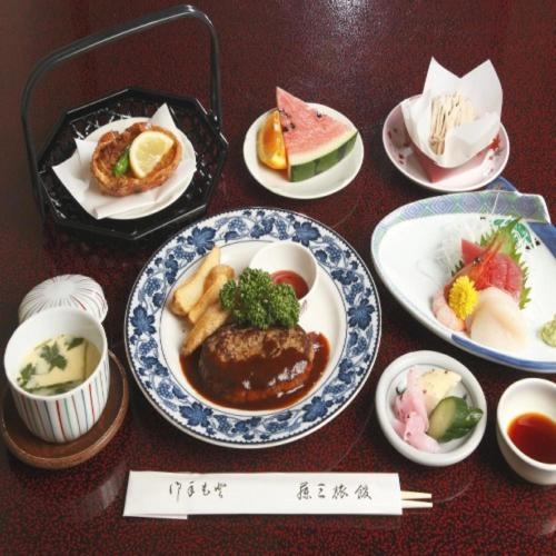 a table topped with plates of food on plates at Fujisan Ryokan in Hanamaki