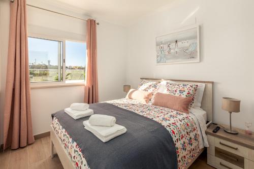Un dormitorio con una cama con toallas. en Apartamento Sunset on the Sea, en Albufeira