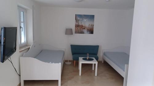 Habitación pequeña con cama, silla y mesa. en Im Stüble, en Koetz 