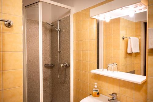 a bathroom with a shower and a sink and a mirror at Gasthof Großmann in Heidenreichstein