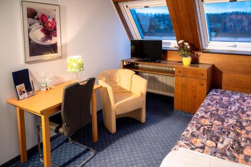 una camera d'albergo con scrivania, letto e sedia di Gasthof Großmann a Heidenreichstein