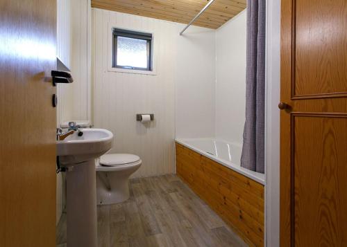 a bathroom with a toilet and a sink and a bath tub at Lochearnhead Loch Side in Lochearnhead