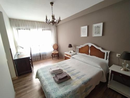 um quarto com uma cama, uma janela e uma cadeira em Apartamento Centro y Playa em Gijón