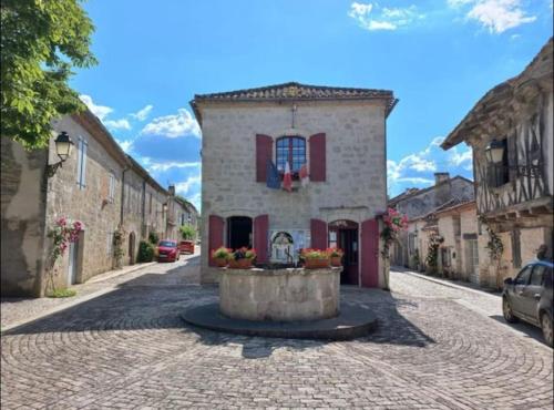 un edificio con una fuente en medio de una calle en Maison dans la magnifique village de Montjoi, en Monjoi