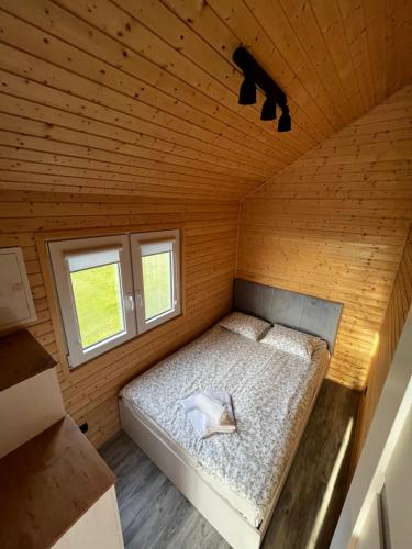 ein Schlafzimmer mit einem Bett in einem Holzzimmer in der Unterkunft RYBY W SIECI in Władysławowo