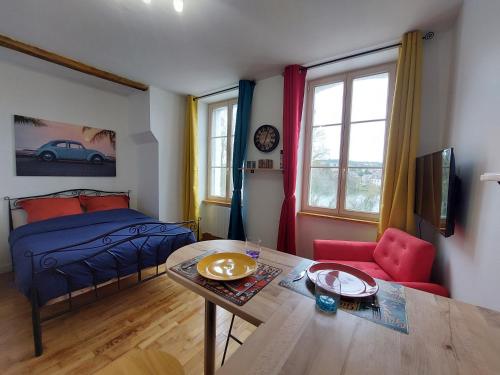 - une chambre avec un lit et une table ainsi qu'une salle à manger dans l'établissement Kilomètre 99, à Pont-sur-Yonne