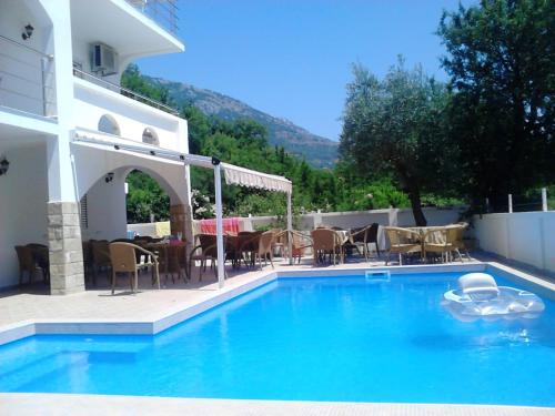 a swimming pool with a table and chairs next to a house at Bonaca in Sutomore