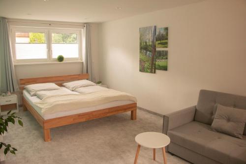 1 dormitorio con 1 cama y 1 sofá en Ferienwohnung der Familie Rauch, en Mühlhausen