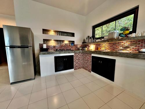 a kitchen with a stainless steel refrigerator and a tile floor at KohTao Studios Sunset in Koh Tao