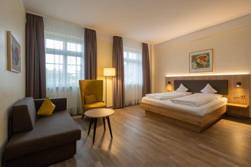 a hotel room with a bed and a chair at Hotel Niedersächsischer Hof in Goslar