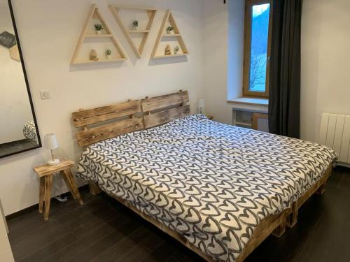 een slaapkamer met een bed met een houten hoofdeinde en een raam bij Maison 10 personnes, isolée. in Grandes Sables