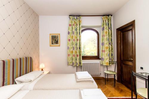 a bedroom with two beds and a window at Villa La Ginestra - Charming Country Home in Capolona